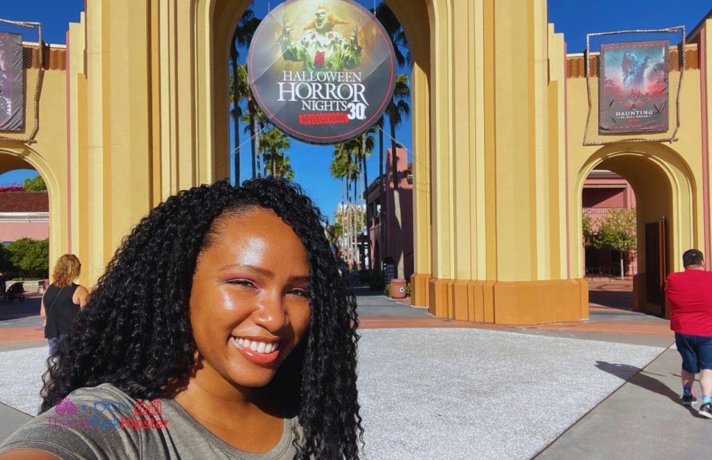 NikkyJ in front of Halloween Horror Nights 30 Sign at Universal Orlando Resort. Keep reading to find out more about Scare zones at Halloween Horror Nights.