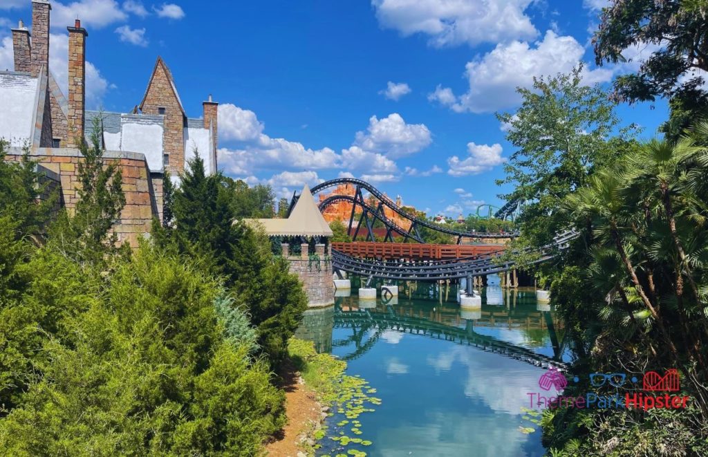 Universal Orlando Resort Velocicoaster going over lagoon viewing from hogsmeade at harry potter world at Islands of Adventure back of Three Broomsticks