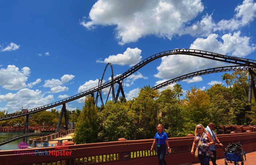 Universal Orlando Resort VelociCoaster twist at Islands of Adventure with theme park guests walking past. Keep reading to discover more about Hulk vs VelociCoaster at Universal Orlando.