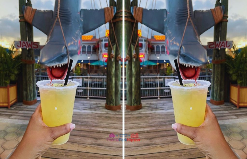 Universal Orlando Resort a margarita at Chez Alcatraz with Jaws Bruce the Shark in background at Universal Studios. Keep reading to learn how to get free Universal Studios tickets with the 2 park 2 day ticket.