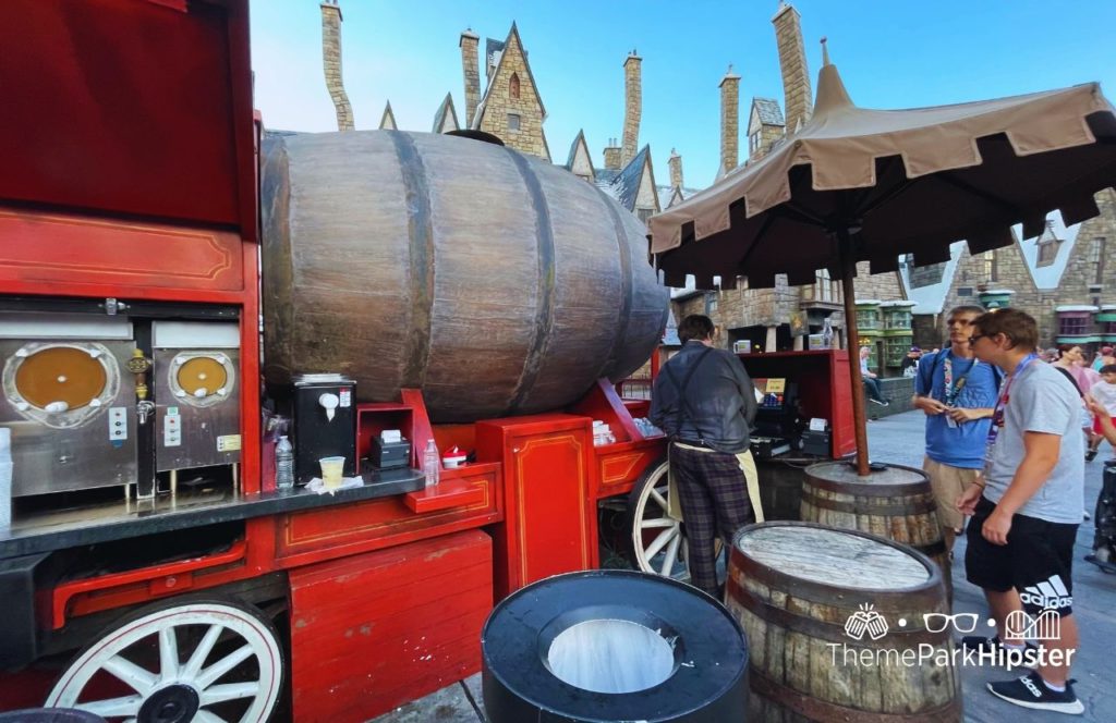 Red Butterbeer Stand with barrels surrounded it in Harry Potter World Hogsmeade Universal Orlando Resort Islands of Adventure. Keep reading to find out what are the best Universal Orlando Snacks under $10.