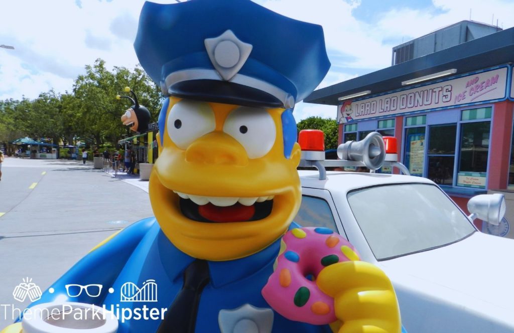 Universal Orlando Resort Cop in Springfield Simpsons Land at Universal Studios Florida eating a pink doughnut. One of the best Universal Studios photos.