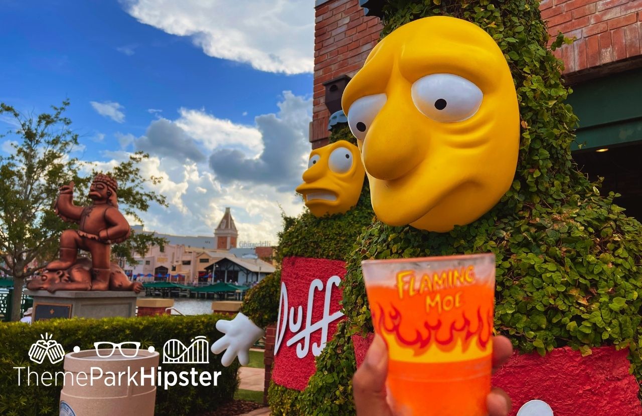 Universal Orlando Resort Flaming Moe orange drink in Simpsons Land next to duff beer garden at Universal Studios Florida