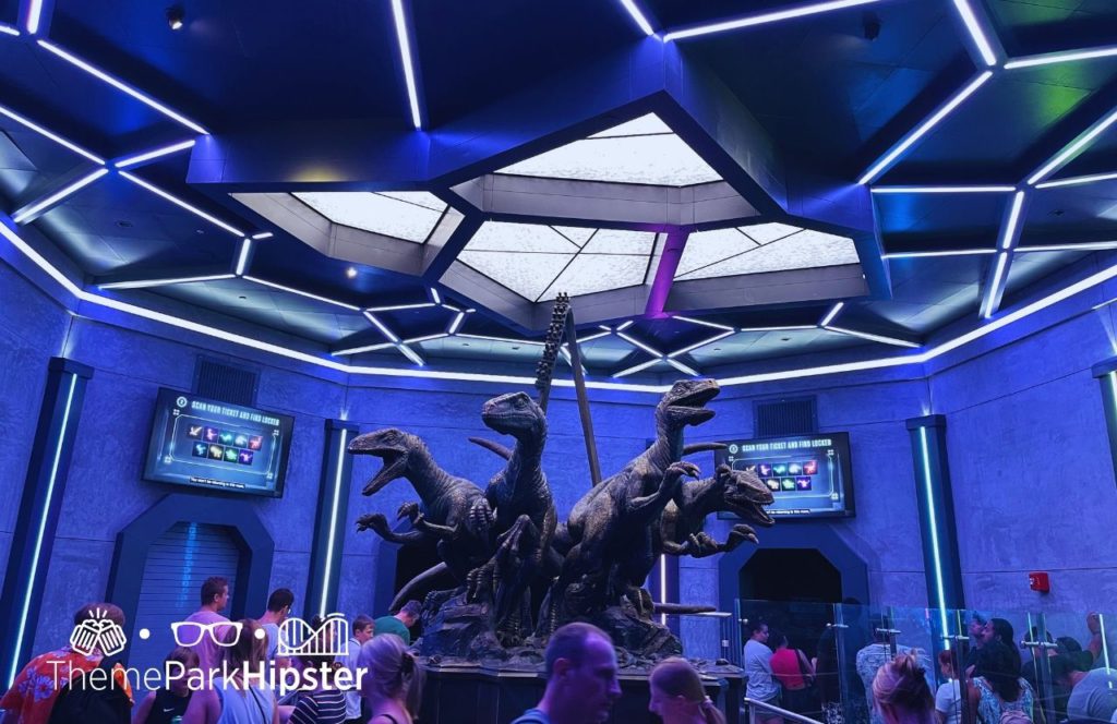 VelociCoaster queue with dinosaur statues and theme park guests walking through the queue experience at Universal Orlando Resort Islands of Adventure.  Keep reading to learn more tips for your Universal Orlando solo trip 2024.