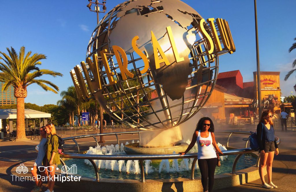 NikkyJ in front of the Globe Universal Studios Hollywood California. Keep reading to get the full 2024 Universal Studios Hollywood Crowd Calendar and to know when is the best time to visit Universal Studios Hollywood.