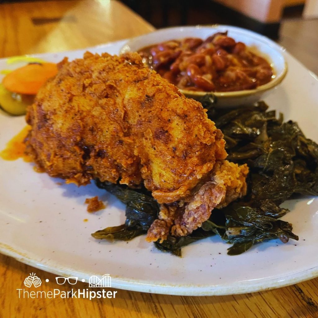Boatwrights Dining Hall at Disney Port Orleans Resort Fried Nashville Chicken with Greens and Baked Beans. Keep reading to learn how to do Thanksgiving Day at Disney World.