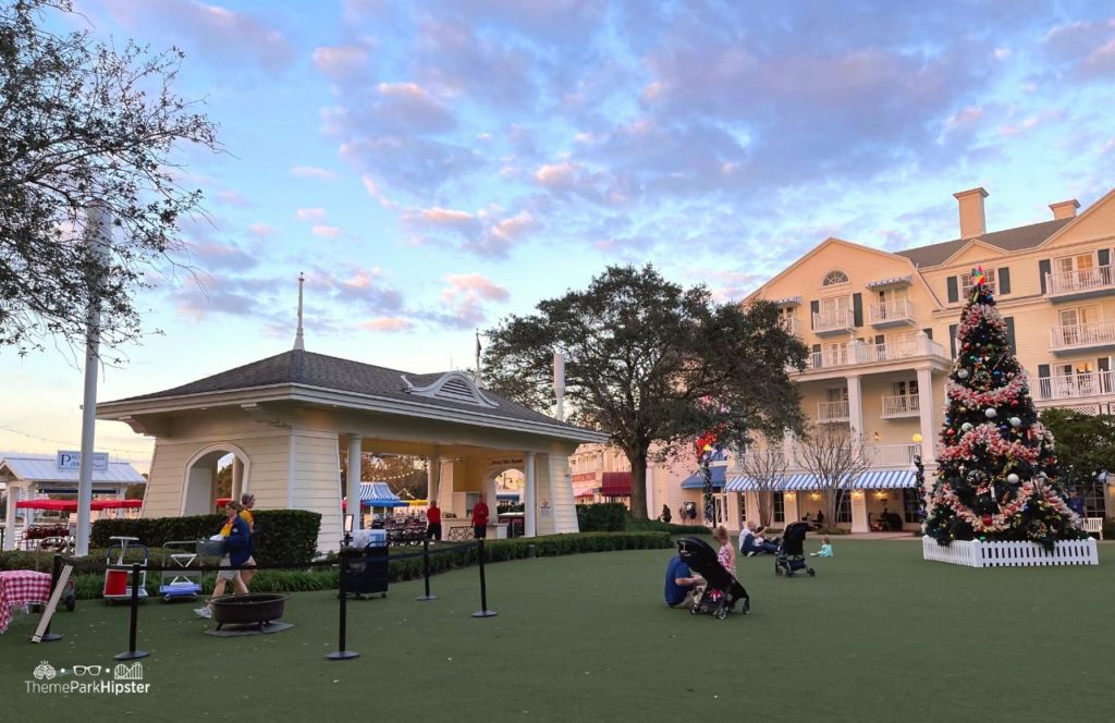 Christmas at Disney Boardwalk Inn and Villas Christmas Tree on Green Lawn with Cast Member prepping smores