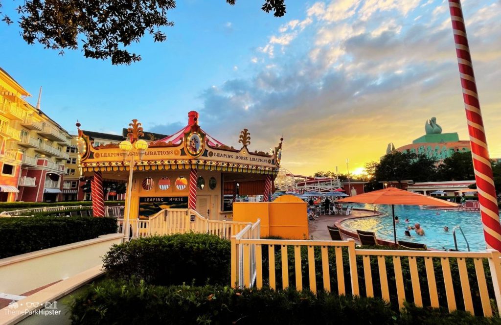 Christmas at Disney Boardwalk Inn and Villas Pool area of Leaping Horse Libations Bar with Swan Resort in background. One of the best Disney World resorts for adults.