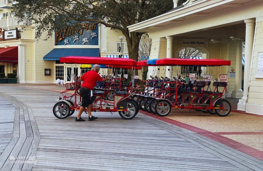 Christmas at Disney Boardwalk Inn and Villas Surrey Bike Rental man pushing red cart. Keep reading to know how to choose the best Disney Deluxe Resorts for your vacation.