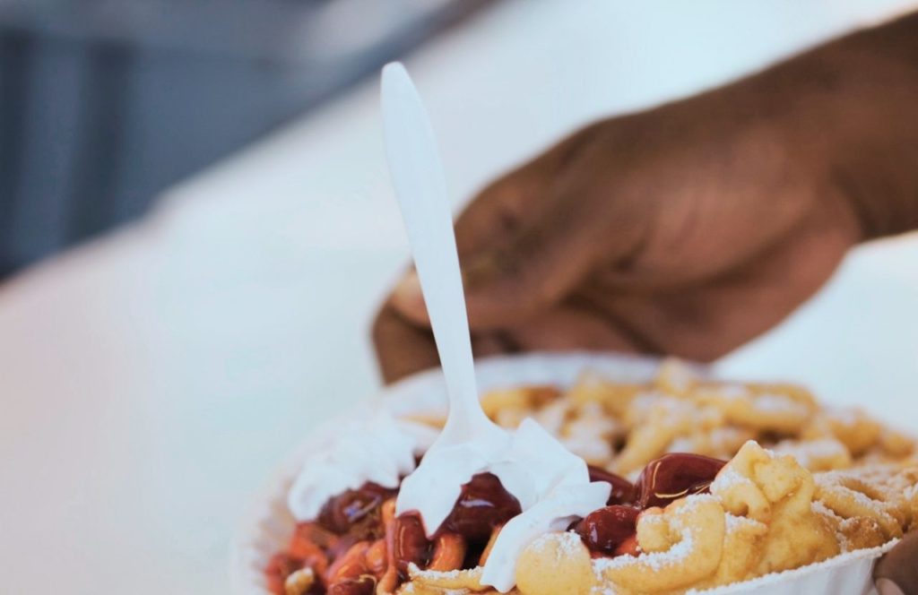 Knott's Berry Farm in California Whip Cream Powered Sugar and Berries on top of Funnel Cake. Keep reading to get the best food at Knott's Berry Farm and the best things to eat.