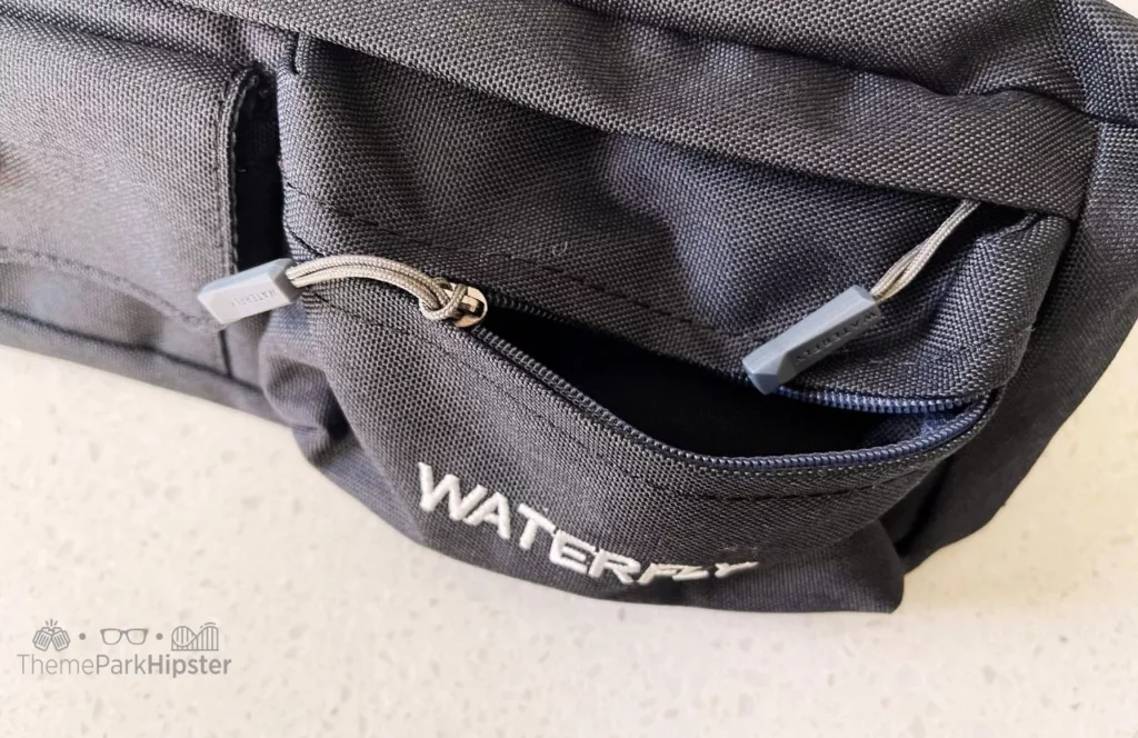 One of the best fanny packs for Disney World is Waterfly gray waist pack up close of front pocket