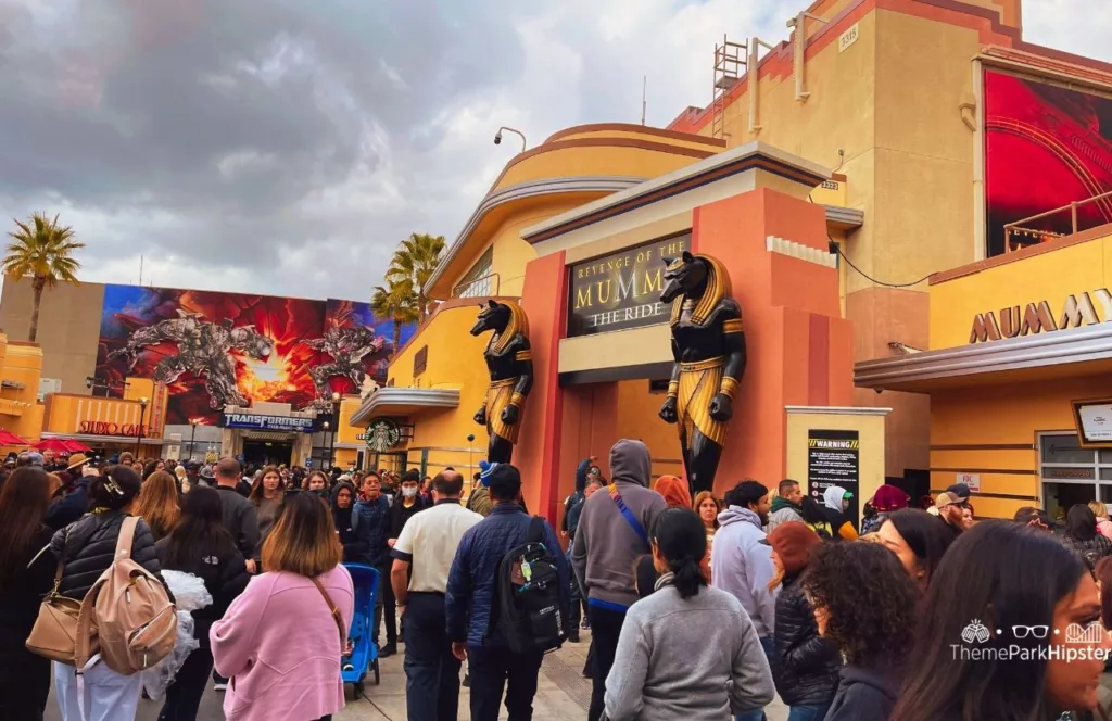 Universal Studios Hollywood Revenge of the Mummy and Transformers the Ride area with a crowd walking in front. Keep reading to find out more of the best Universal Studios Hollywood attractions for solo travelers.