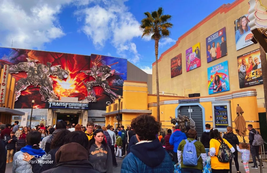 Universal Studios Hollywood Transformers the Ride 3D next to character on a crowded day. Keep reading to get the full Universal Studios Hollywood Crowd Calendar and to know when is the best time to visit Universal Studios Hollywood.