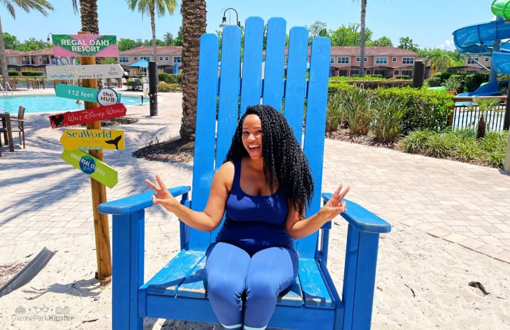 Regal Oaks Resort Near Disney World Vacation Home Pool Area with NikkyJ in Big Blue Chair. Keep reading to get an understanding on Walt Disney’s Quote on Courage.