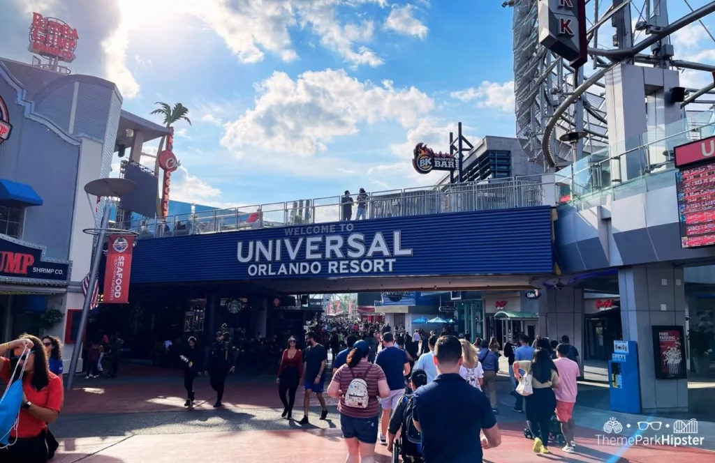 Universal Orlando Resort Welcome Sign at CityWalk with lots of people walking and standing around. Keep reading to discover 10 things to know before you go to Universal Orlando Resort in 2024.