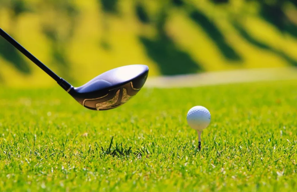 Golf ball sitting aside the hole on the gold course. Keep reading to discover the top 10 best things to do near Hersheypark.