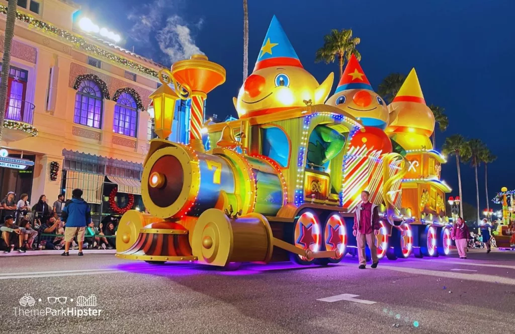 Christmas at Universal Orlando Holiday Parade featuring Macy's with a big colorful train. Keep reading if you want to discover more about Macy’s Holiday Parade at Universal Studios Florida.