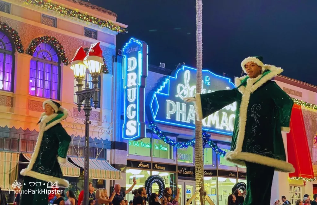 Christmas at Universal Orlando Holiday Parade featuring christmas stilt walkers. Keep reading to find out all you need to know about Universal Studios Holiday Parade.