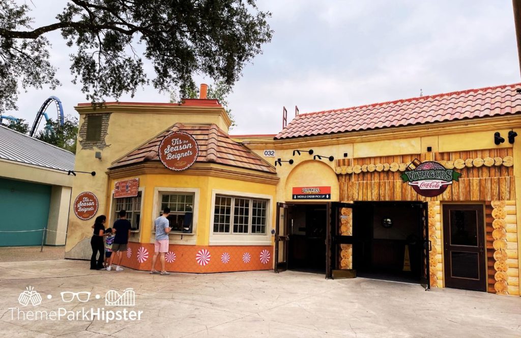 One of the best things to eat at SeaWorld Orlando Christmas Celebration Tis the Season Beignets next to Voyager's Smokehouse Mobile Order Pick Up