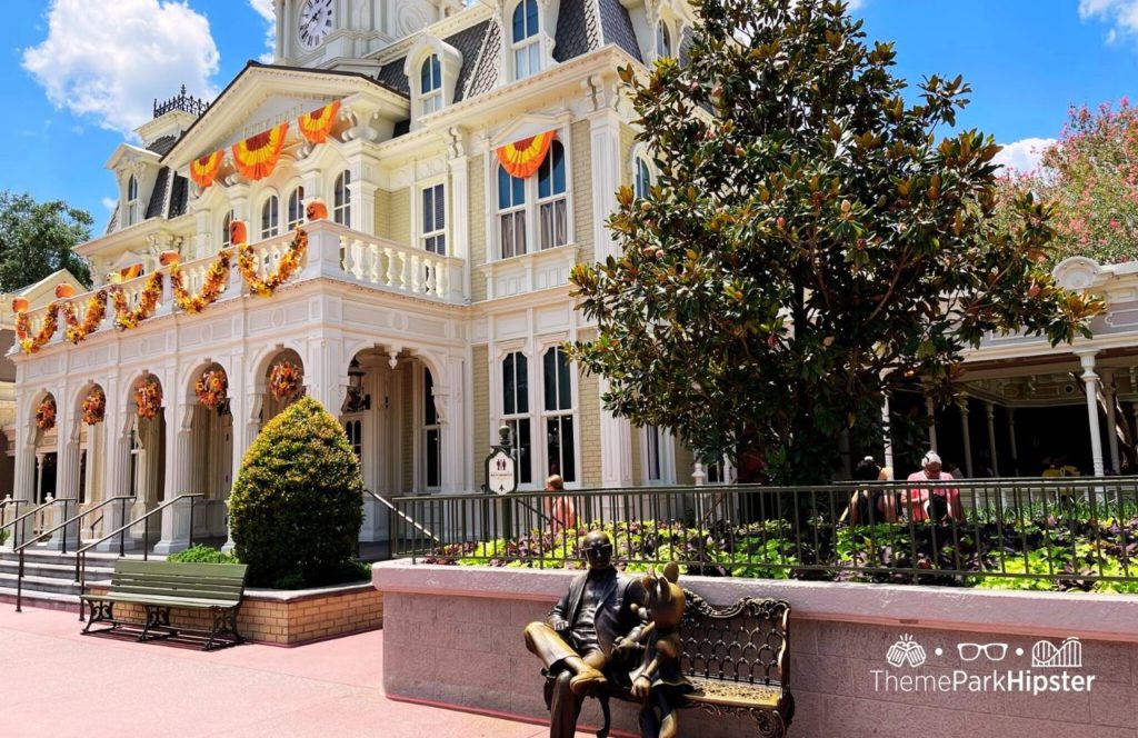 Disney Magic Kingdom Park Main Street USA with Roy Disney and Minnie Mouse Statue on Main Street USA next to Guest Services with Fall decorations