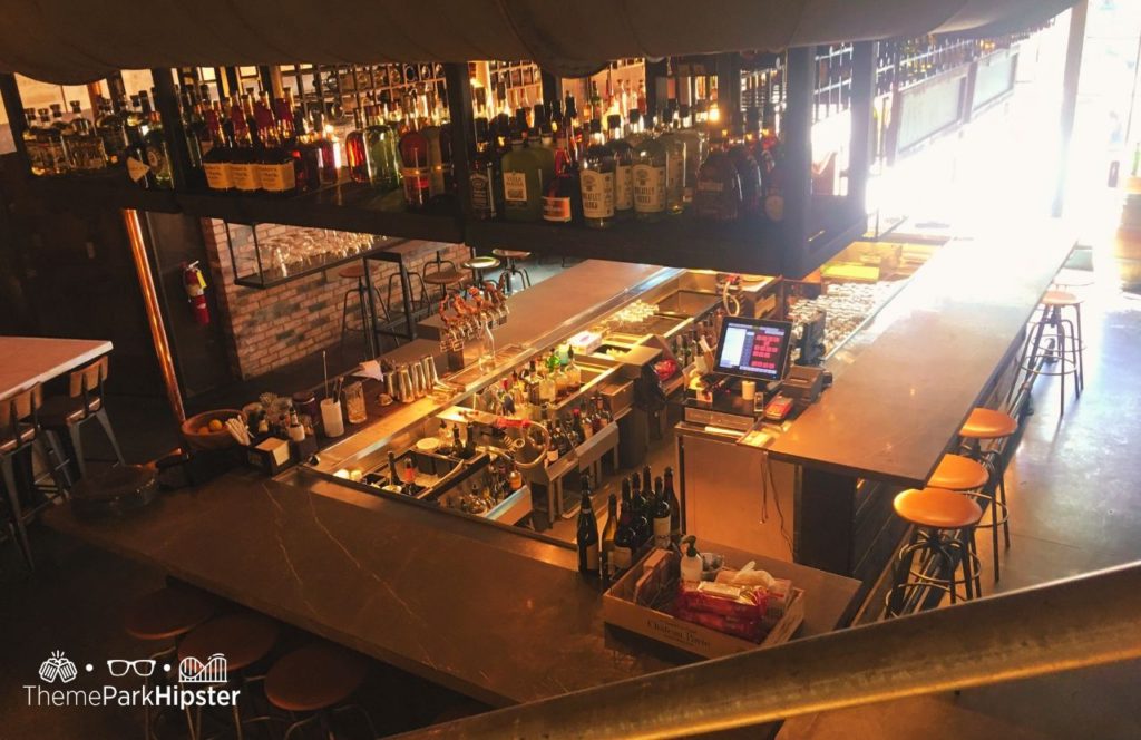 Walt Disney World Disney Springs Wine Bar George Restaurant aerial view of cocktails, wines and liquor beverages. Keep reading to find out more about the best restaurant at Disney Springs Wine Bar George.