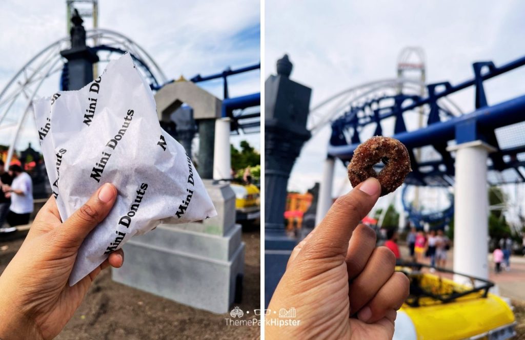 Cedar Point Amusement Park Ohio Mini Donuts with Corkscrew roller coaster in the background. Keep reading to learn more on how to visit Cedar Point in one day.