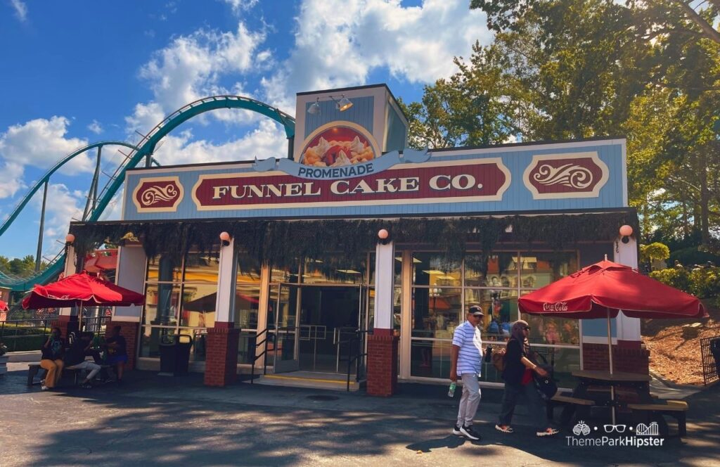 Six Flags Over Georgia Amusement Park Promenade Funnel Cake Co. Restaurant in front Goliath Coaster. Keep reading to find out everything you need to know about visiting Six Flags Over Georgia for the first time.