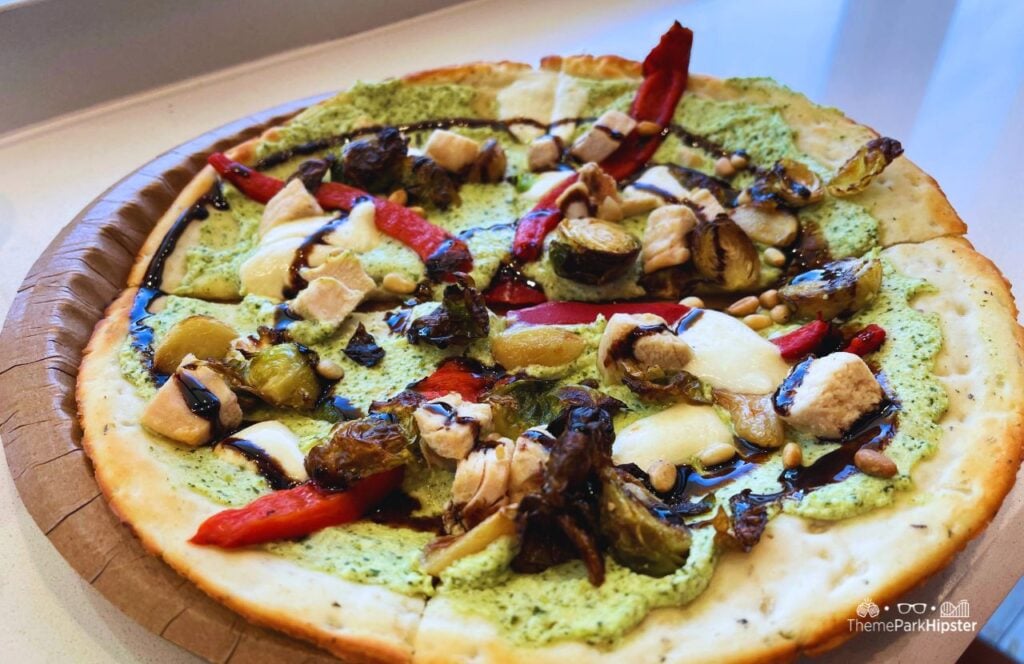 TODAY Cafe Restaurant in Universal Studios Florida Chicken Pesto Flatbread Pizza Food with cauliflower crust, pesto ricotta, grilled chicken, brussels sprouts, red peppers, mozzarella, pine nuts, and a balsamic glaze.