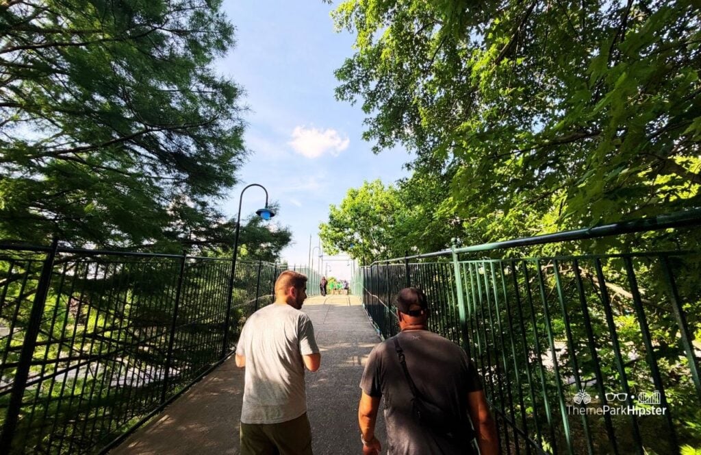 Kentucky Kingdom Amusement Park Louisville Tree filled pathway with two guys walking over bridge